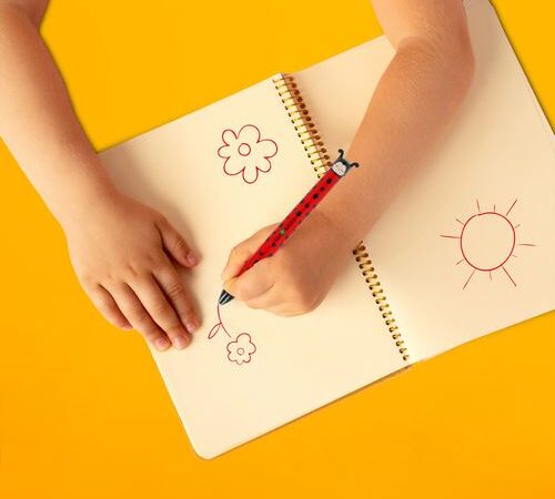 Pessoa a escrever num caderno com a caneta Legami joaninha destacando a ergonomia do produto