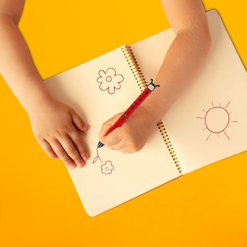 Pessoa a escrever num caderno com a caneta Legami joaninha destacando a ergonomia do produto