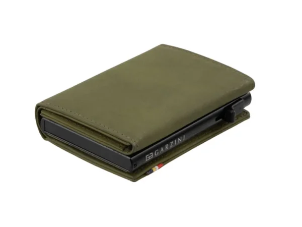 A Carteira Garzini MagSafe Metal Wallet Verde Azeitona surge aberta sobre um fundo branco. Além disso, a Carteira Garzini MagSafe Metal Wallet Verde Azeitona destaca-se pela sua elegante textura de couro legítimo.